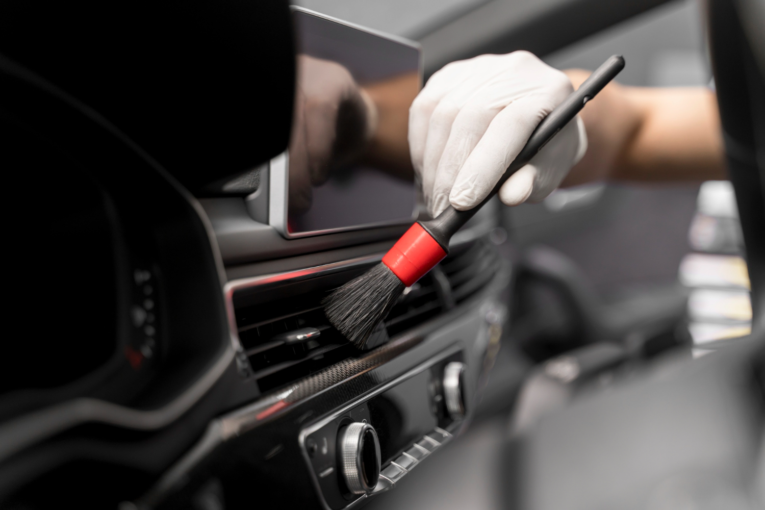 Cleaning dashboard interior with a brush